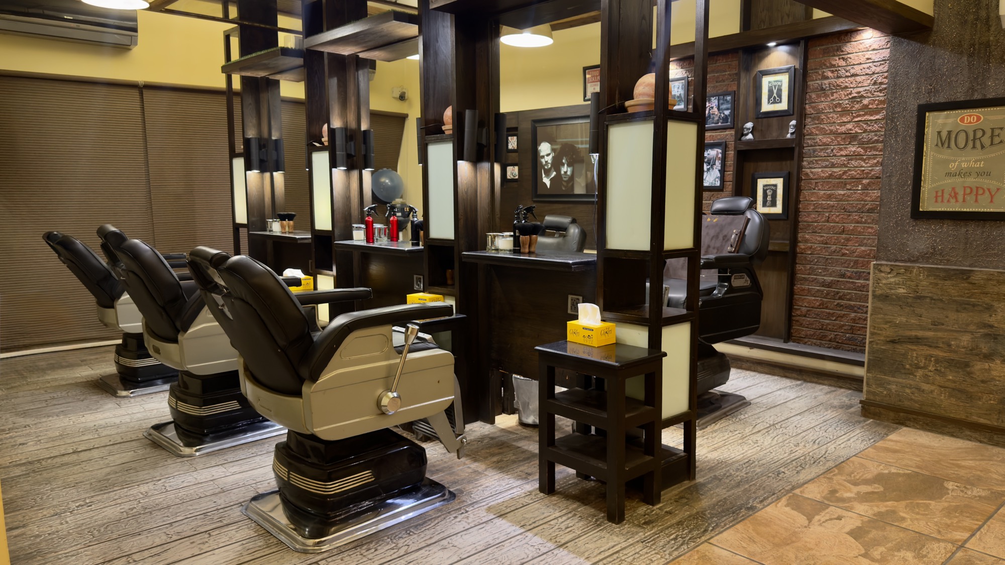A row of vintage barber chairs facing lit wooden stations at the Stadium branch