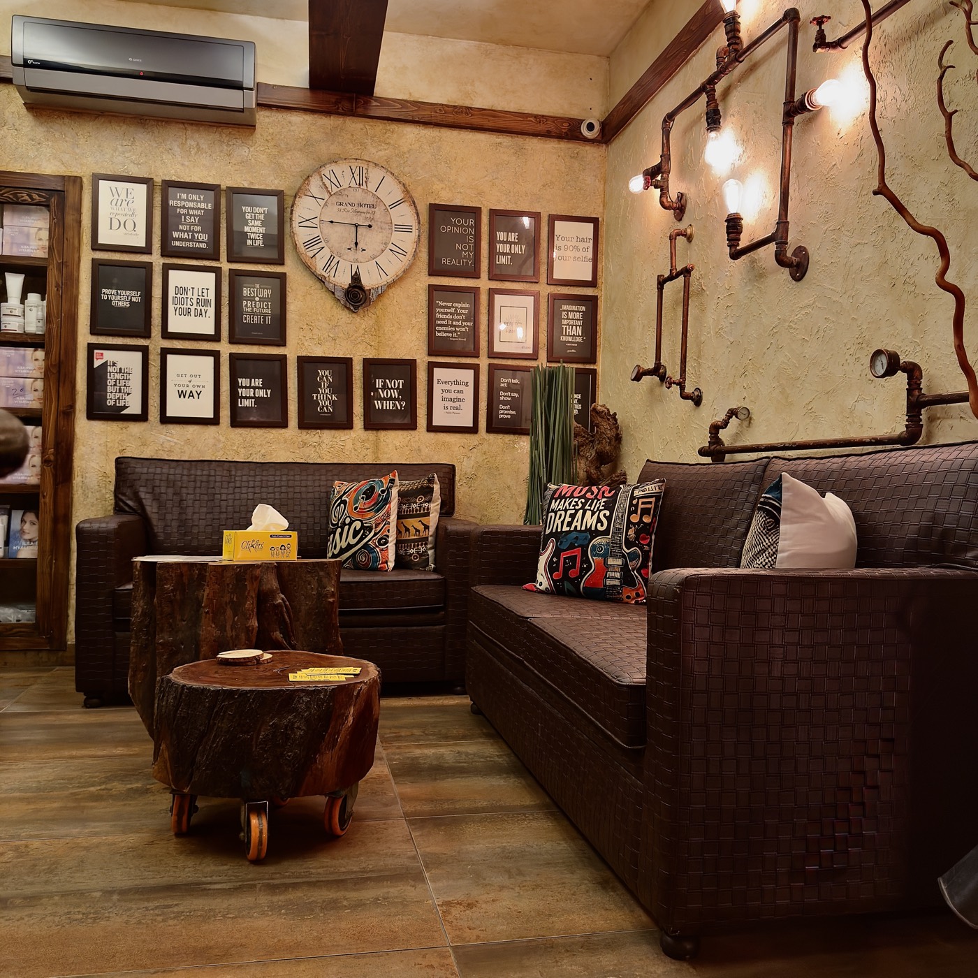 Leather sofas under a wall of framed pictures and a clock at the Zamzama branch