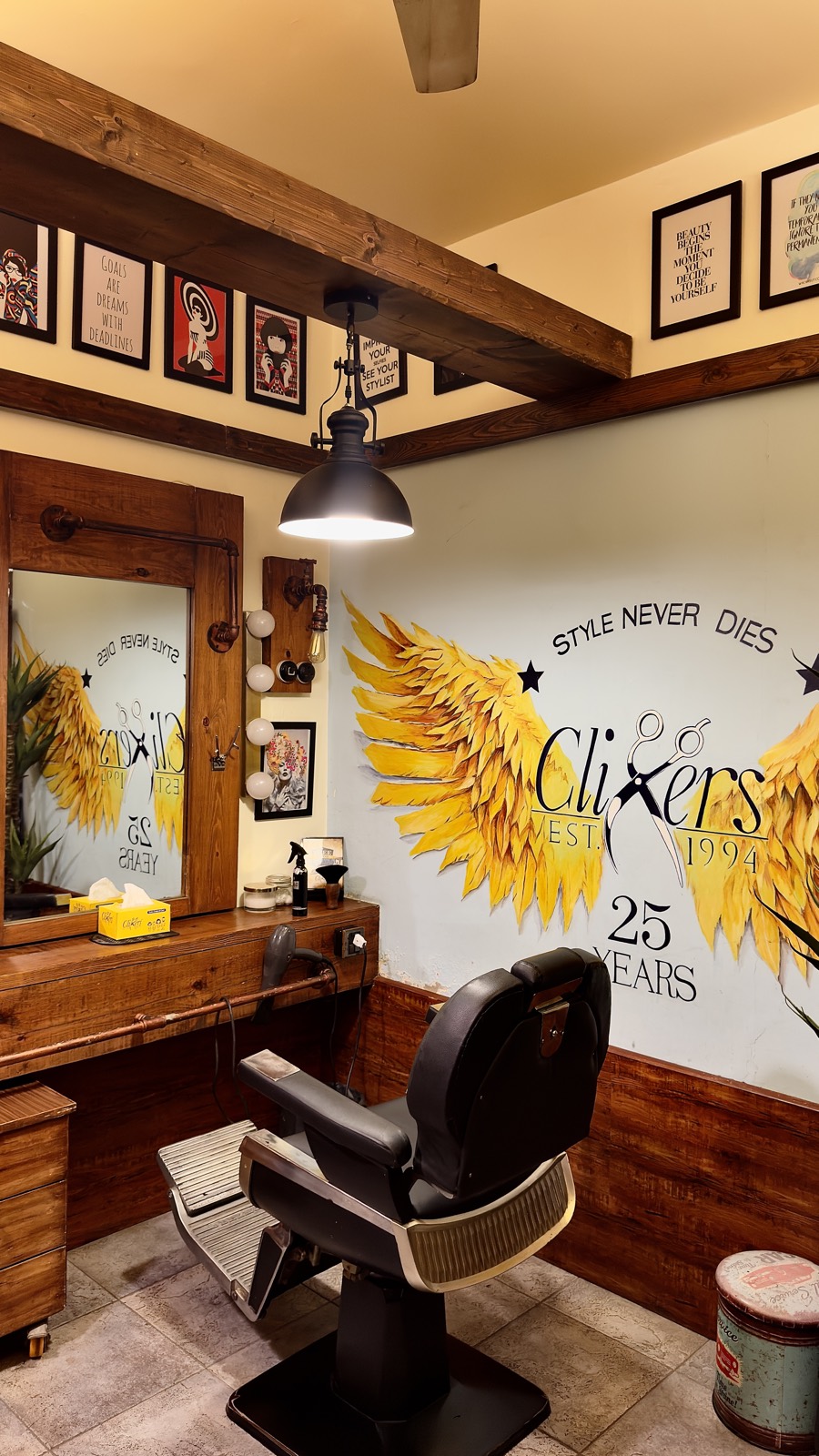 A vintage barber chair in front of the gold wings mural at the Zamzama branch